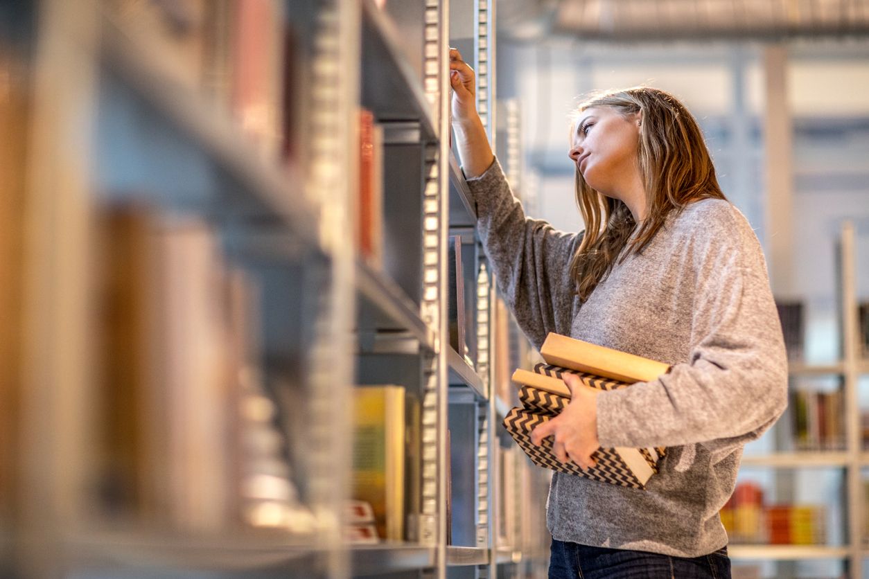 Beautiful female university student studying on campus library